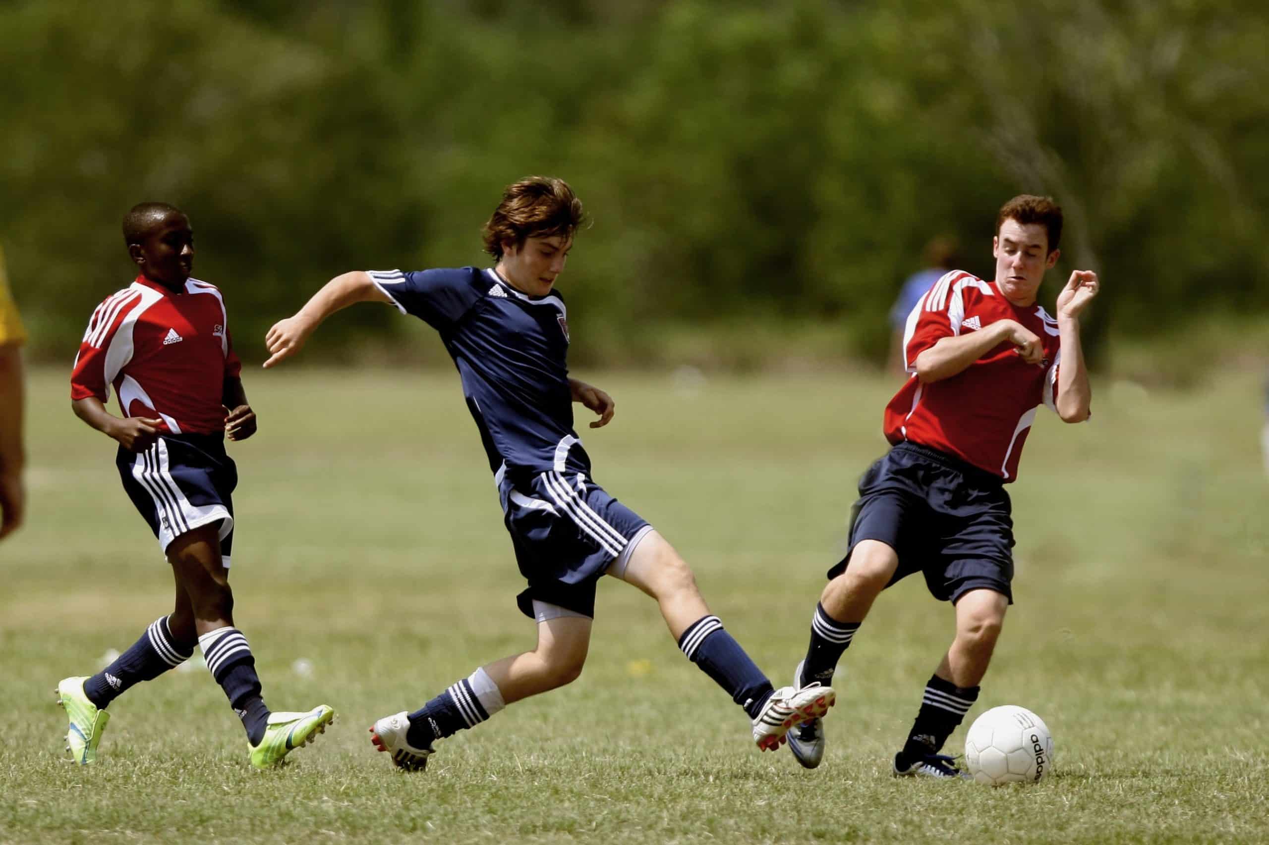 youth soccer players in red and blue uniforms
